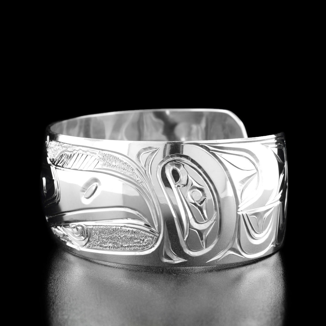 Right angle photo of the bracelet shows carved designs representing the raven's feathers.