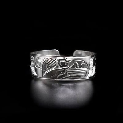 This 3/4" Raven Bracelet is hand carved by Heiltsuk artist Ivan Wilson. He has used sterling silver to create this piece.  The bracelet measures 6.5" in length by 0.75" width with a 0.5" gap.     The Raven Legend Represents: CREATIVITY, MISCHIEF, MAGIC.