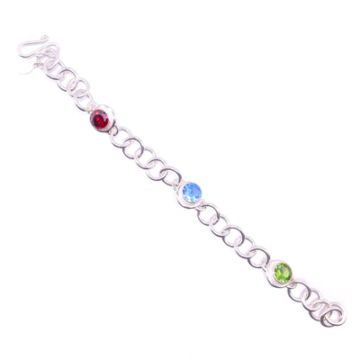 Triple Gemstone Bracelet handmade by Janet Stein. The bracelet is made using sterling silver for the chainlinks connecting the 3 gemstones: blue topaz, garnet, and peridot.