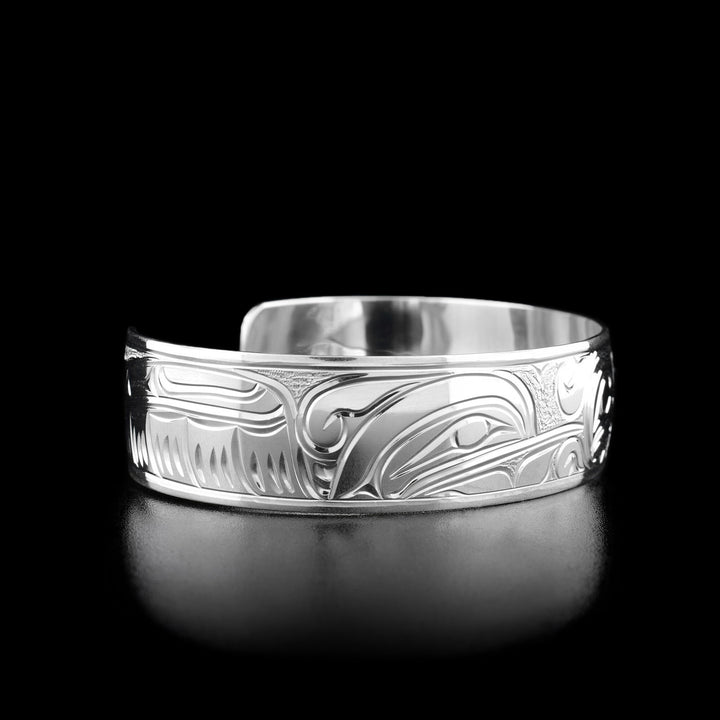 Left angle photo of the bracelet shows carved designs representing the wing of one of the hummingbirds. Other side of the bracelet is identical.
