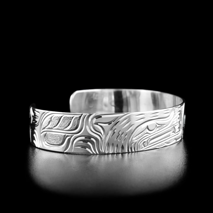 Left angle photo of the bracelet shows carved designs representing the body and fur of the bear.