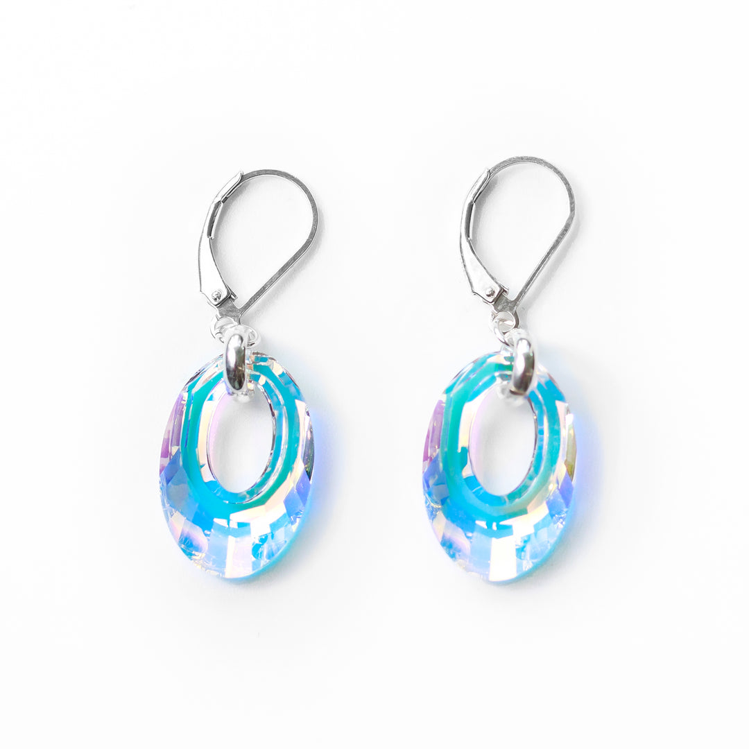 The crystal hoop earrings are made from sterling silver and Aurora Borealis Swarovski Crystals. The lever back hooks are made from silver and the hangs are oval shaped crystals and have large cutouts in the center of them making them look like hoops.
