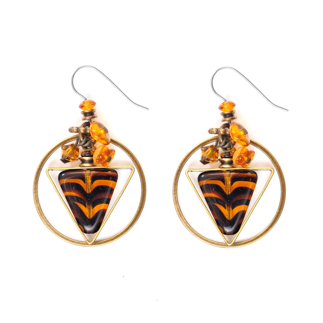 These amber earrings feature tiger-print dyed glass in the center with orange crystal cluttered above and a brass circle around each earring.