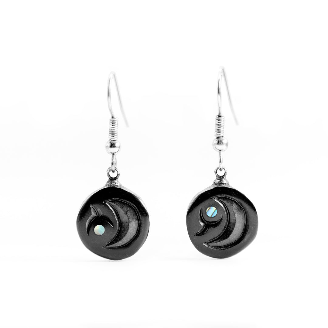 These abalone earrings are made with small, circle pieces of argillite that are carved to depict the egg of the Salmon. The hangs dangle down and there are small abalone pieces accenting the hangs,