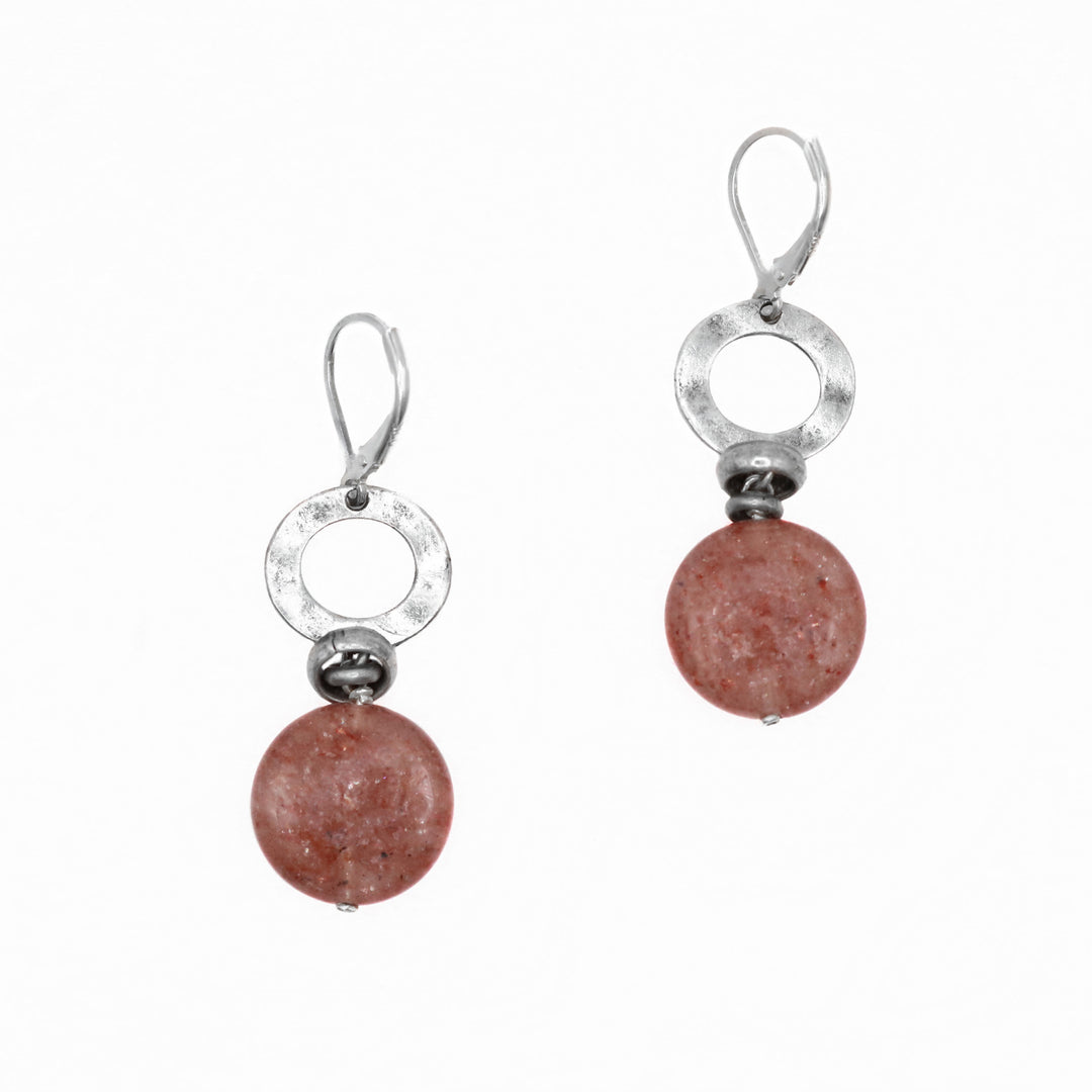 These gemstone drop earrings have been made using sterling silver and muscovite gemstones. There are cutout circle pieces made from silver and below them are circle shaped, red gems.