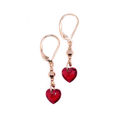These crystal heart earrings are heart-shaped and red in colour. The hooks and bails are gold-filled and between them are small gold-filled sphere adornments.
