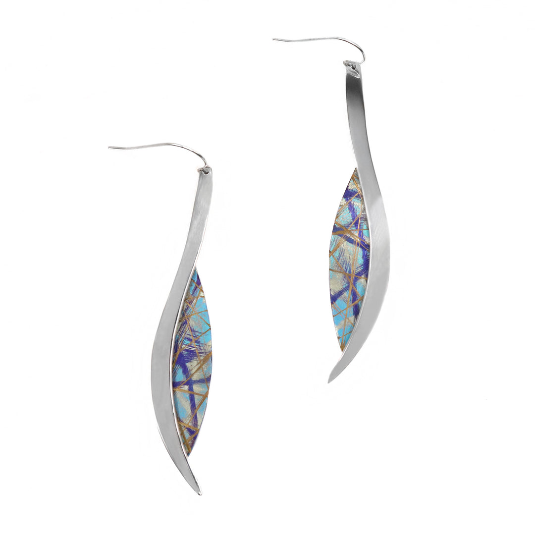 These titanium dangle earrings are made from sterling silver and anodized titanium. There is a teardrop shaped titanium piece that has turquoise, purple and gold designs on the surface of it achieved by anodizing the metal. There is a silver band that runs along the side of the titanium and extends past it on both ends.