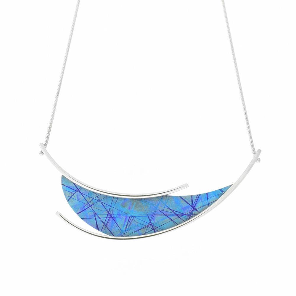 This unique titanium necklace is made from sterling silver and anodized titanium with a vertical, teardrop shaped pendant. The pendant is blue and has colorful designs achieved by anodizing the titanium and there are silver wires that run across the pendant.