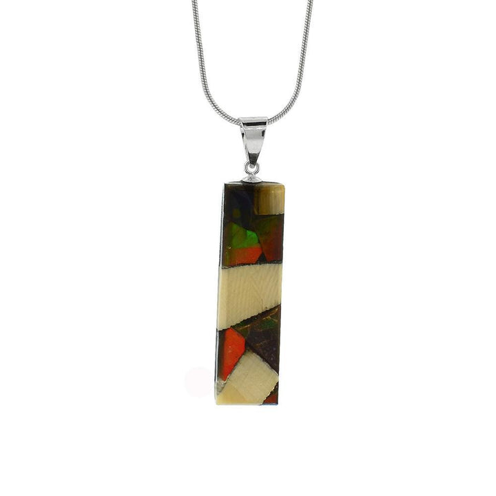 This unique ivory pendant is made from fossilized mammoth ivory, ammolite gemstones and sterling silver. The pendant is thin and rectangular and is made by casting pieces of ivory and ammolite together. The jump ring is made from sterling silver.