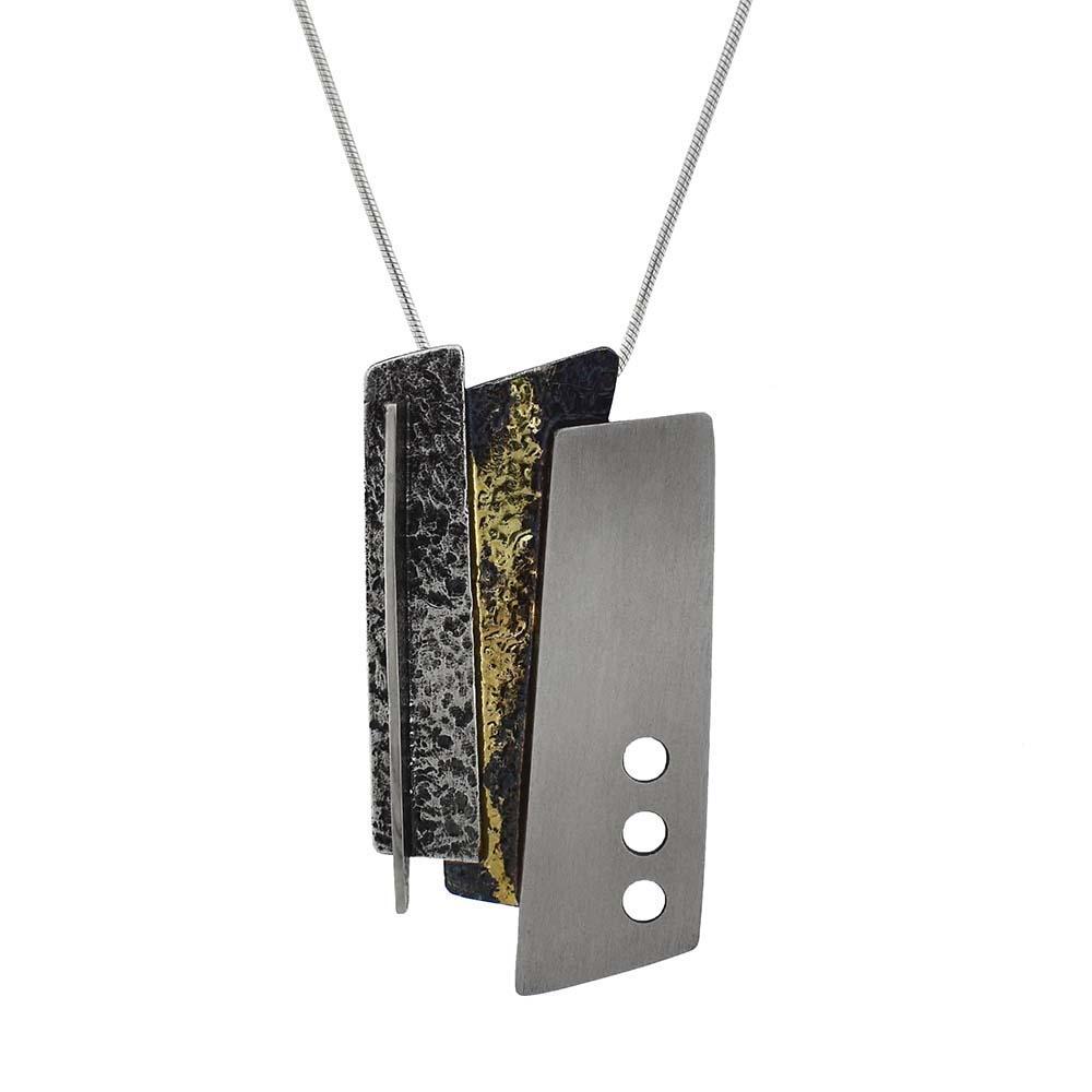 This oxidized silver necklace is made from sterling silver, oxidized sterling silver, and gold solder. The pendant is made up of a polished silver rectangle with two oxidized silver rectangles attached together. There are gold solder highlights on the oxidized sections of the pendant.