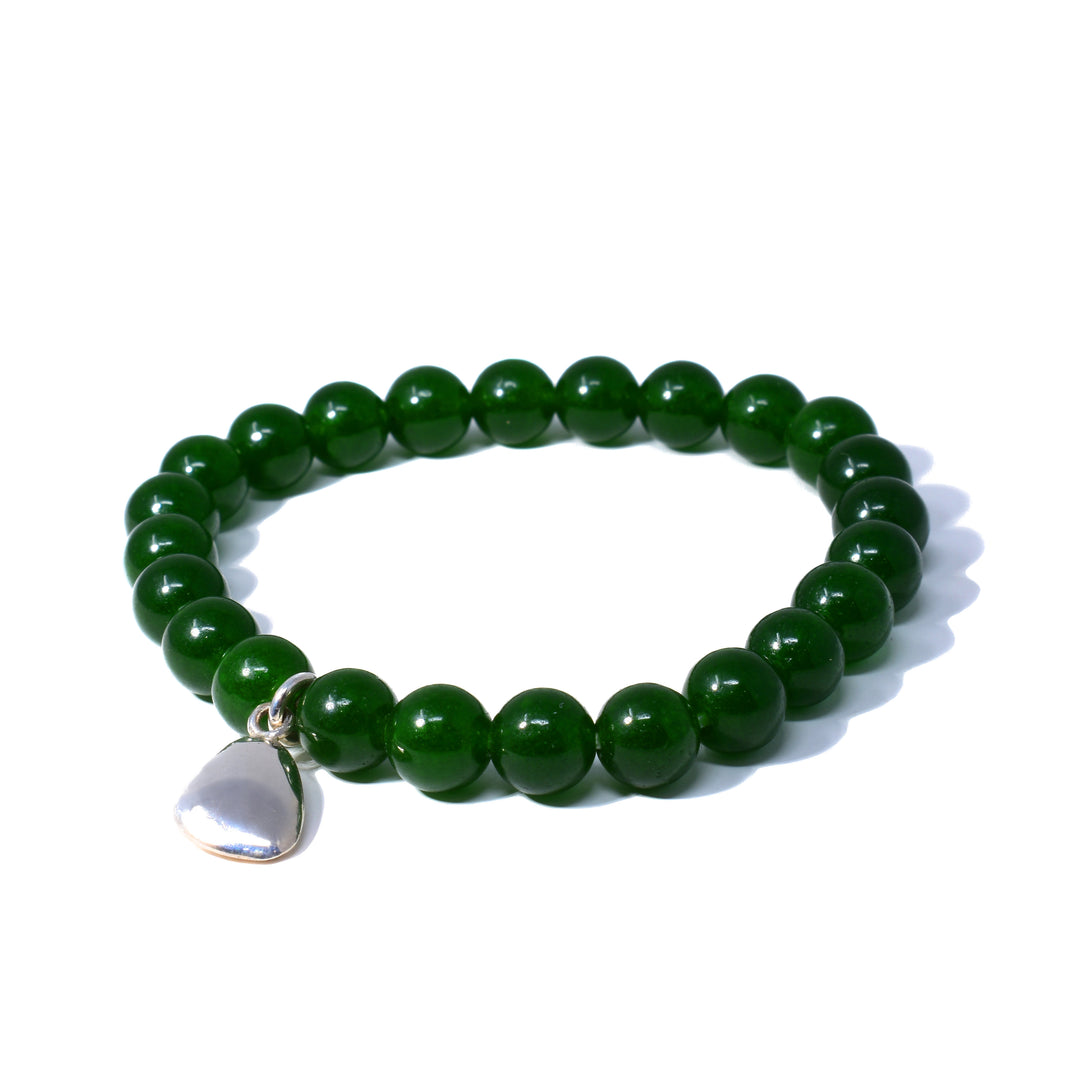 This beaded quartz bracelet is made from sterling silver and polished terra quartz beads. The beads have a deep, green color and are 8mm spheres. There is a sterling silver charm dangling off the bracelet.