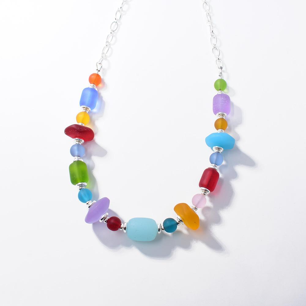 This sterling silver chain and glass bead necklace has beads on the lower half of the necklace. The beads all have different shapes and colors to them.