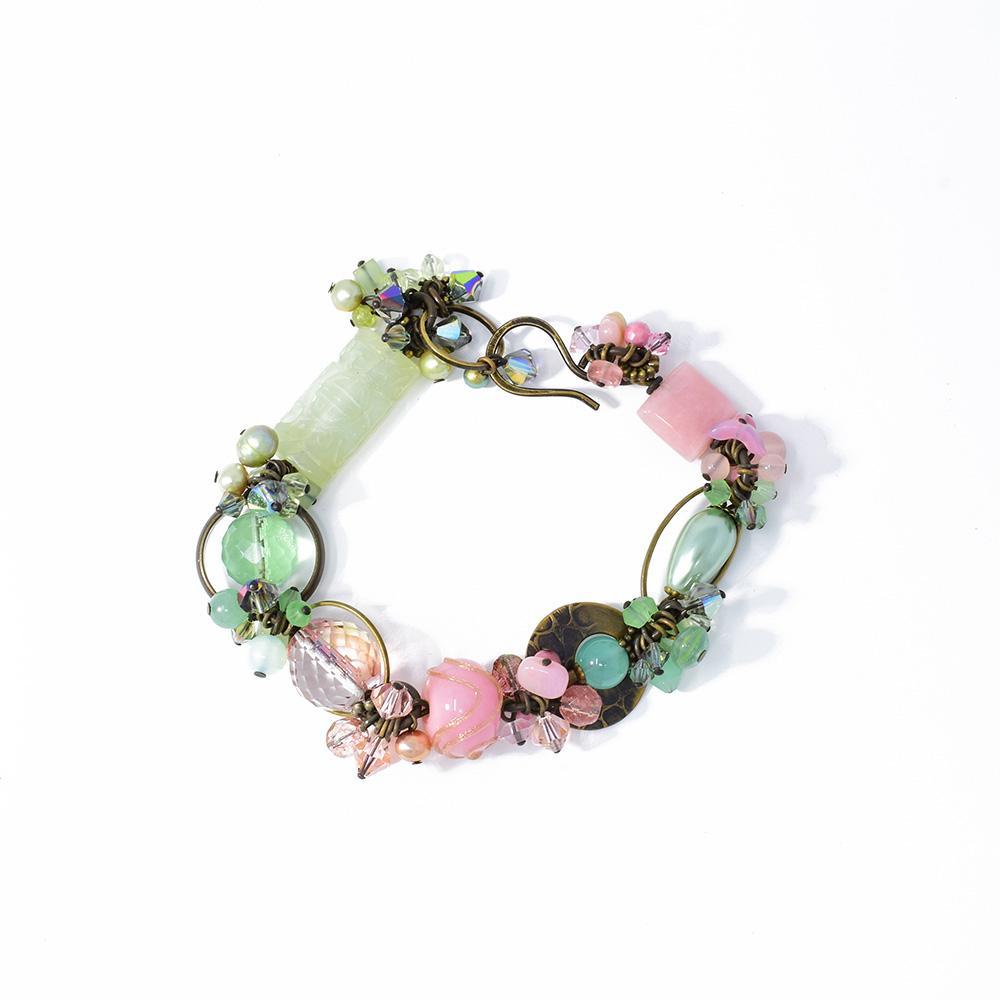 This gemstone and crystal bead bracelet is made from hand worked brass freshwater pearls, lamp worked glass, Swarovski crystal, aquamarine, glass, rhodonite, fluorite, aventurine and rose quartz. There are beads made form the crystals and gemstones along the entire bracelet. The bead come in a variety of designs and are attached using brass hoops and links.