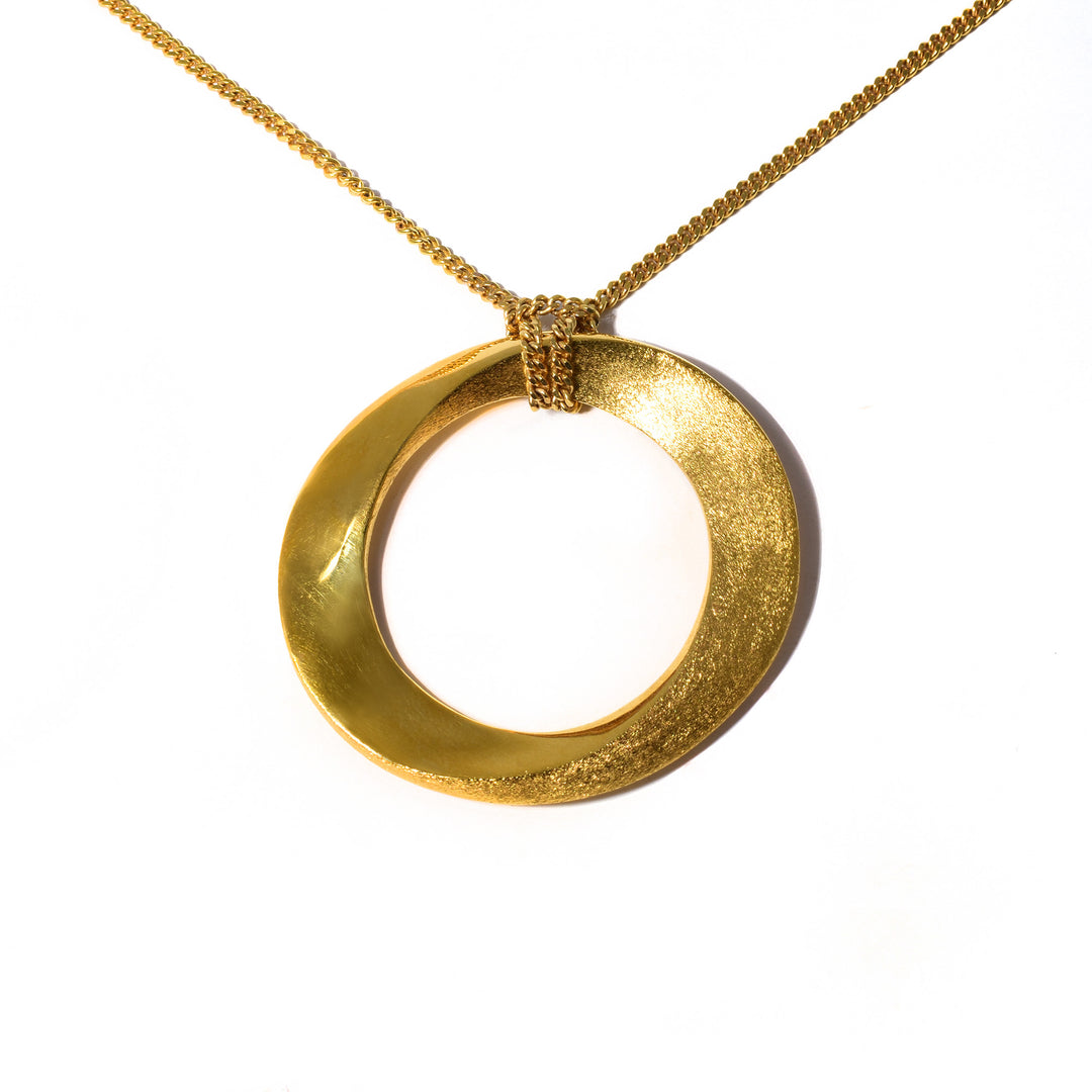 This infinity pendant necklace is made from bronze, 18K gold plating material and a 14K gold filled chain. The pendant is a large hoop and has a unique twist with textured and polished patterns that give it an infinite look.