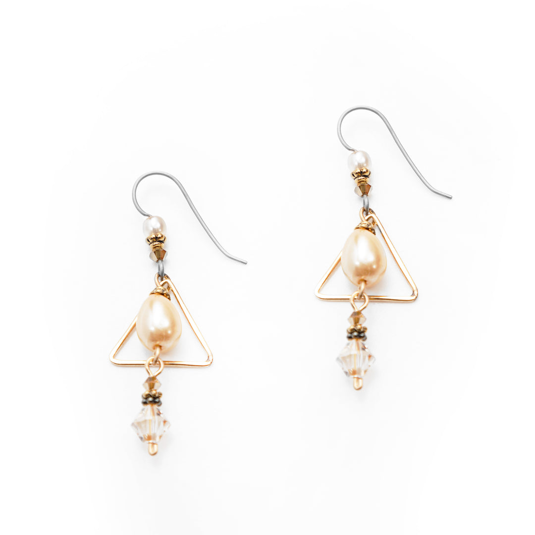 These gold pearl drop earrings have been made using Swarovski crystals, glass beads, gold-filled wire, and fresh water pearls. There are large, teardrop shaped pearls dangling from the hooks and are framed with triangle shaped gold wires. Above and below the triangle are crystal and glass beads that are dangling.