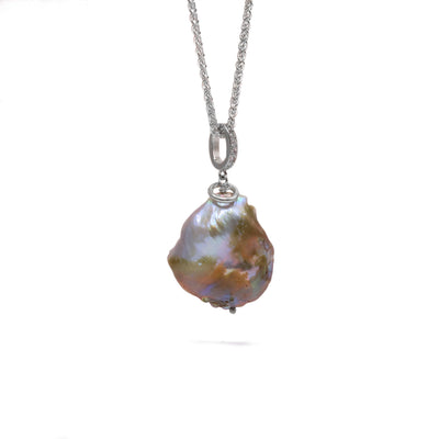 This Freshwater Coin Pearl necklace is handcrafted by artist Wendy Pierson. She has used freshwater coin pearl for the pendant, sterling silver for both the chain and the adornments, and cubic zirconia in the bail for extra shimmer. The necklace is 19.5" long and the pendant measures 1.5" x 0.85".