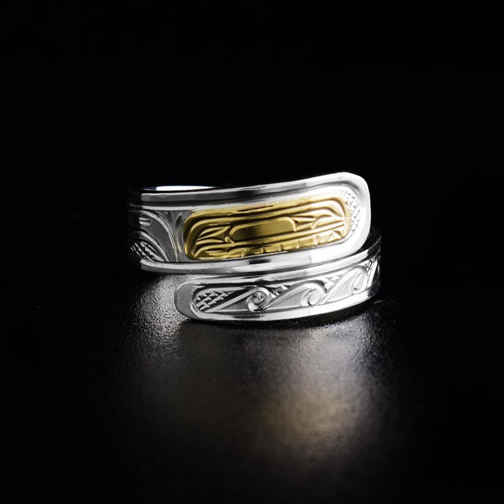 This Orca ring is made from sterling silver and 14K gold. The band is tapered and wraps around the finger twice. There is a depiction of the Orca carved into the surface of the band and the head of the Orca is made from 14K gold.