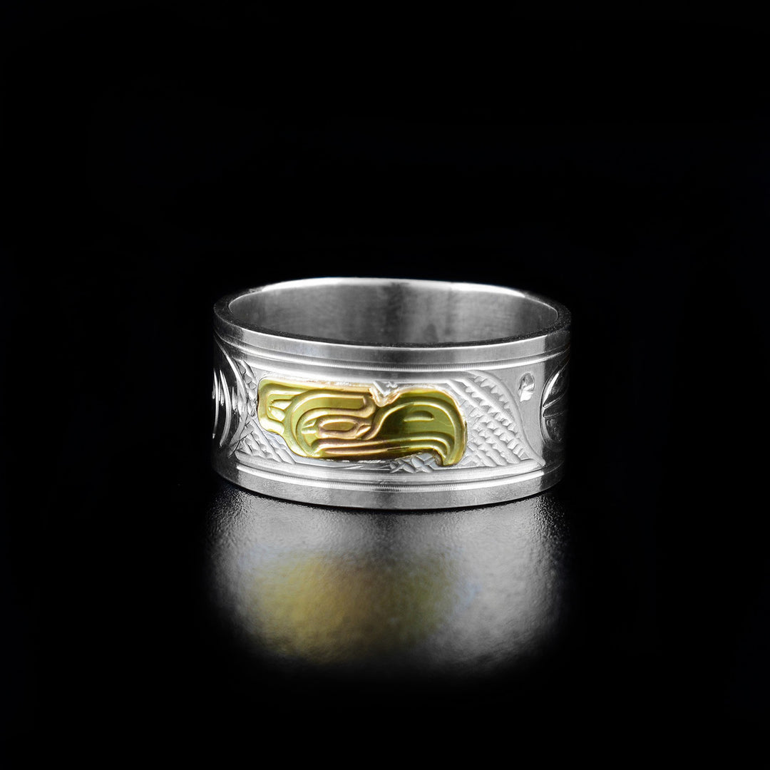 14K Gold and Sterling Silver 3/8" Eagle ring by Victoria Harper. The design depicts the profile of an eagle's head made out of 14k gold facing the right in the center of the ring. On both sides of the eagle's head the artist has hand carved intricate designs using sterling silver.