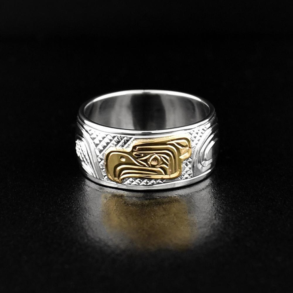This gold Eagle ring is made from sterling silver and 14K gold and has a single wide band. There are carvings on the surface of the band that depict the Eagle. The head of the Eagle has been made from 14K gold.