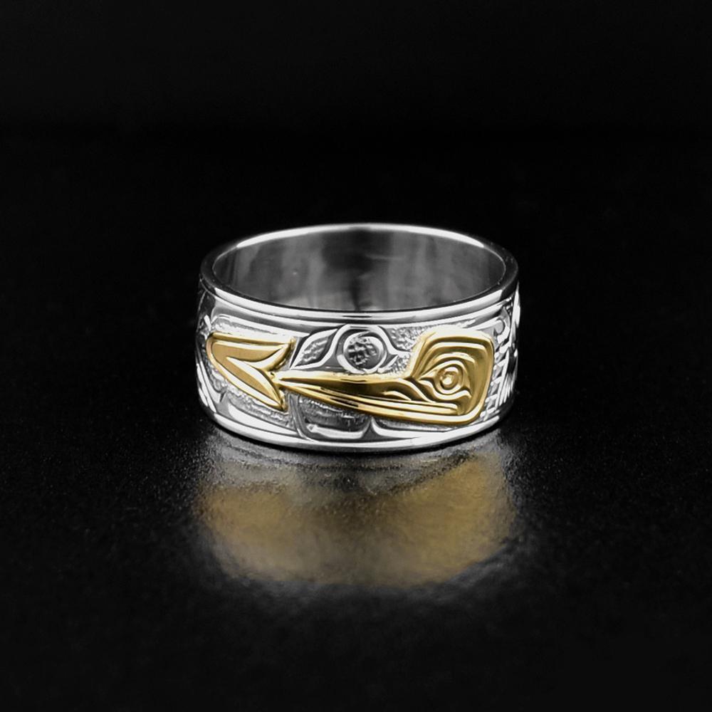 This Hummingbird ring is made from sterling silver and 14K gold and has a wide, single band. There is a depiction of the Hummingbird drinking from a flower carved into the surface of the band. The Hummingbird and flower are made from 14K gold.