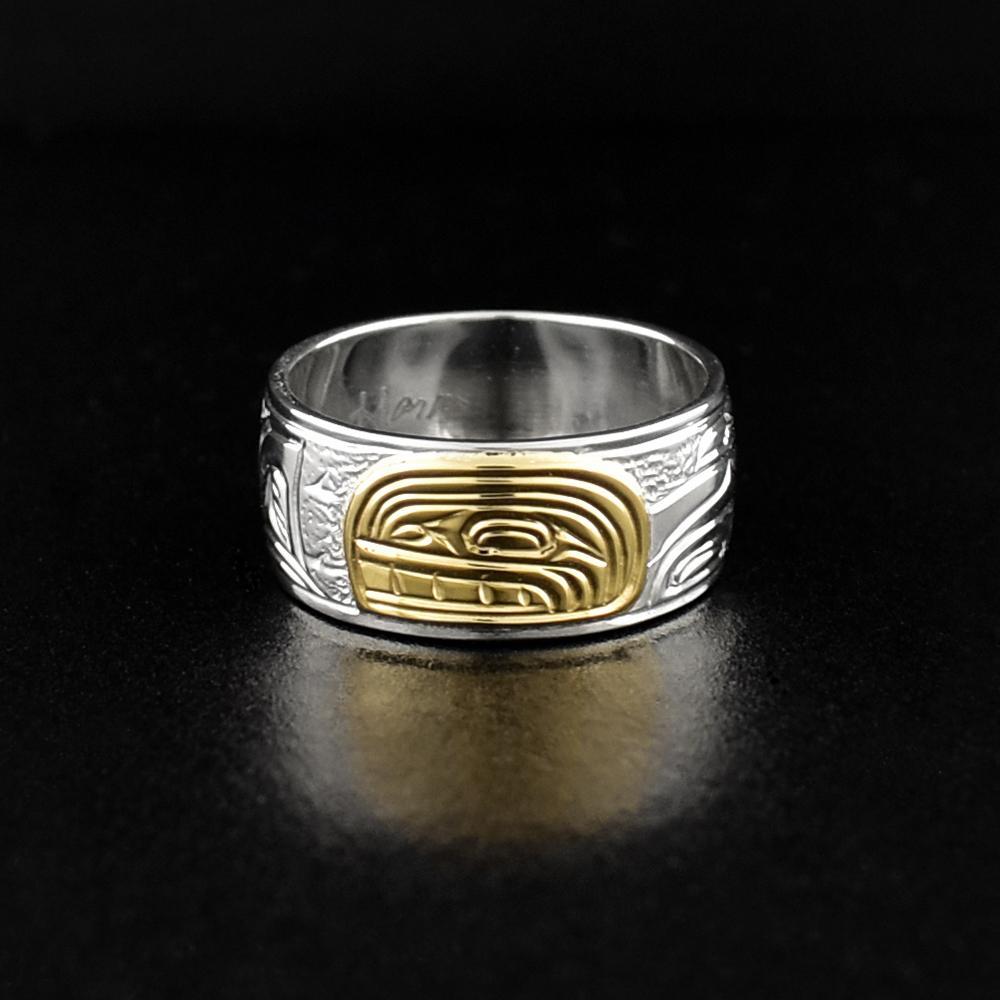 This Orca ring is made from sterling silver and 14K gold and has a single band. There is a depiction of the Orca carved into the surface of the band and the head of the Orca is made from 14K gold.