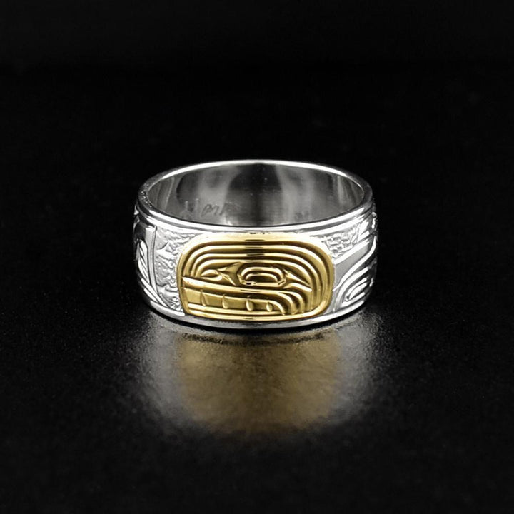 This Orca ring is made from sterling silver and 14K gold and has a single band. There is a depiction of the Orca carved into the surface of the band and the head of the Orca is made from 14K gold.