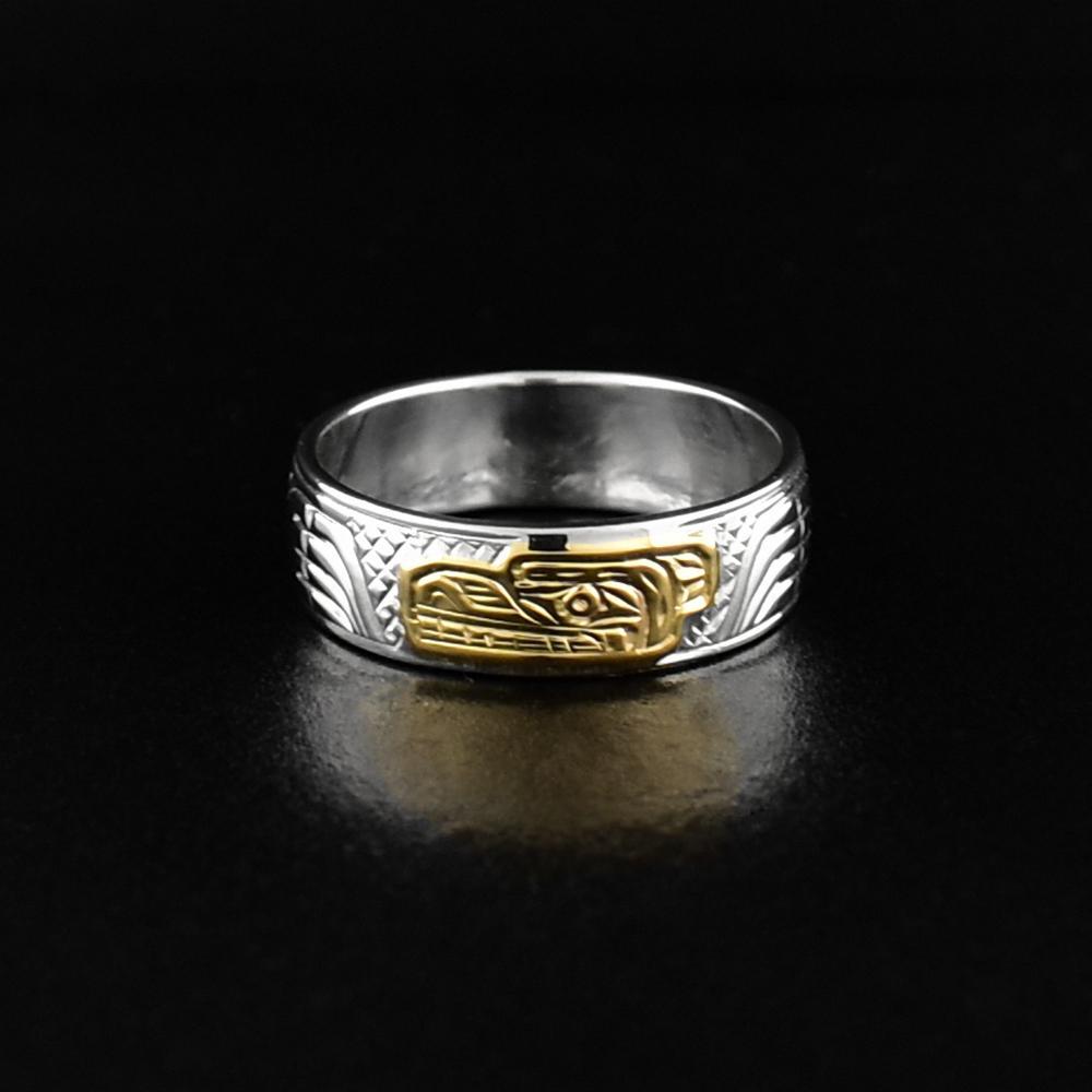 This gold and silver ring is made from sterling silver and 14K gold and has a single band. There is a depiction of the Bear carved into the surface of the band and the head of the Bear is made from 14K gold.