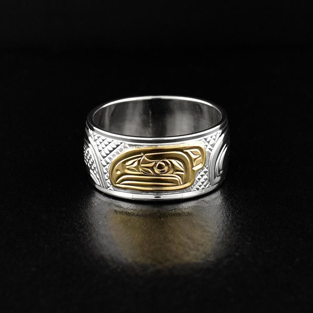 This Raven ring is made from sterling silver and 14K gold and has a single wide band. There is a depiction of the Raven carved into the band and the head of the Raven is made form 14K gold.