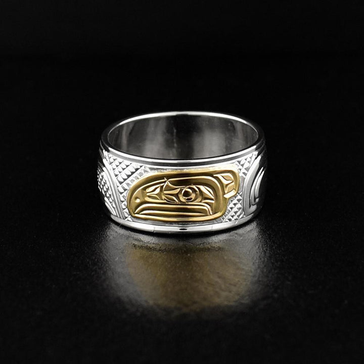 This Raven ring is made from sterling silver and 14K gold and has a single wide band. There is a depiction of the Raven carved into the band and the head of the Raven is made form 14K gold.