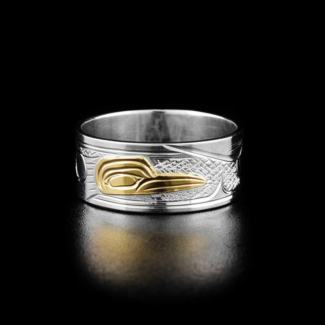 14K Gold and Sterling Silver 3/8" Hummingbird ring by Victoria Harper. The design depicts the head of a hummingbird facing the right made out of 14k gold in the center of the ring. On both sides of the head the artist has hand carved intricate designs representing the hummingbird's body and wings using sterling silver.