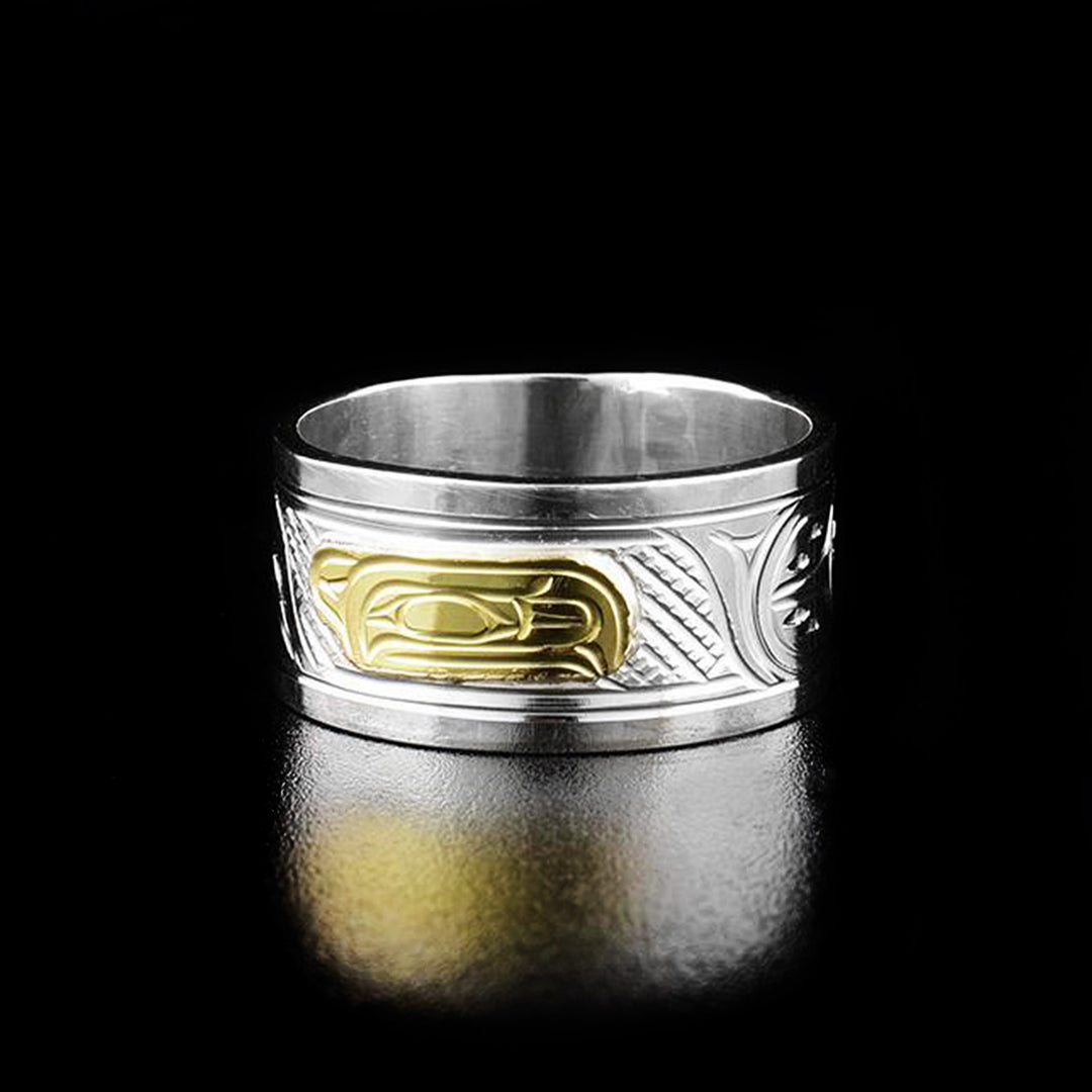 14k Gold and Sterling Silver 3/8" Raven ring by Victoria Harper. The design depicts the profile of a raven's head facing the right made out of 14k gold in the center of the ring. On both sides of the head the artist has hand carved intricate designs using sterling silver.