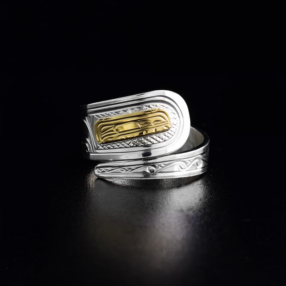 This Orca ring is made from sterling silver and 14K gold. The band is tapered and wraps around the finger twice. There is a depiction of the Orca carved into the band. The head of the Orca is made from 14K gold.