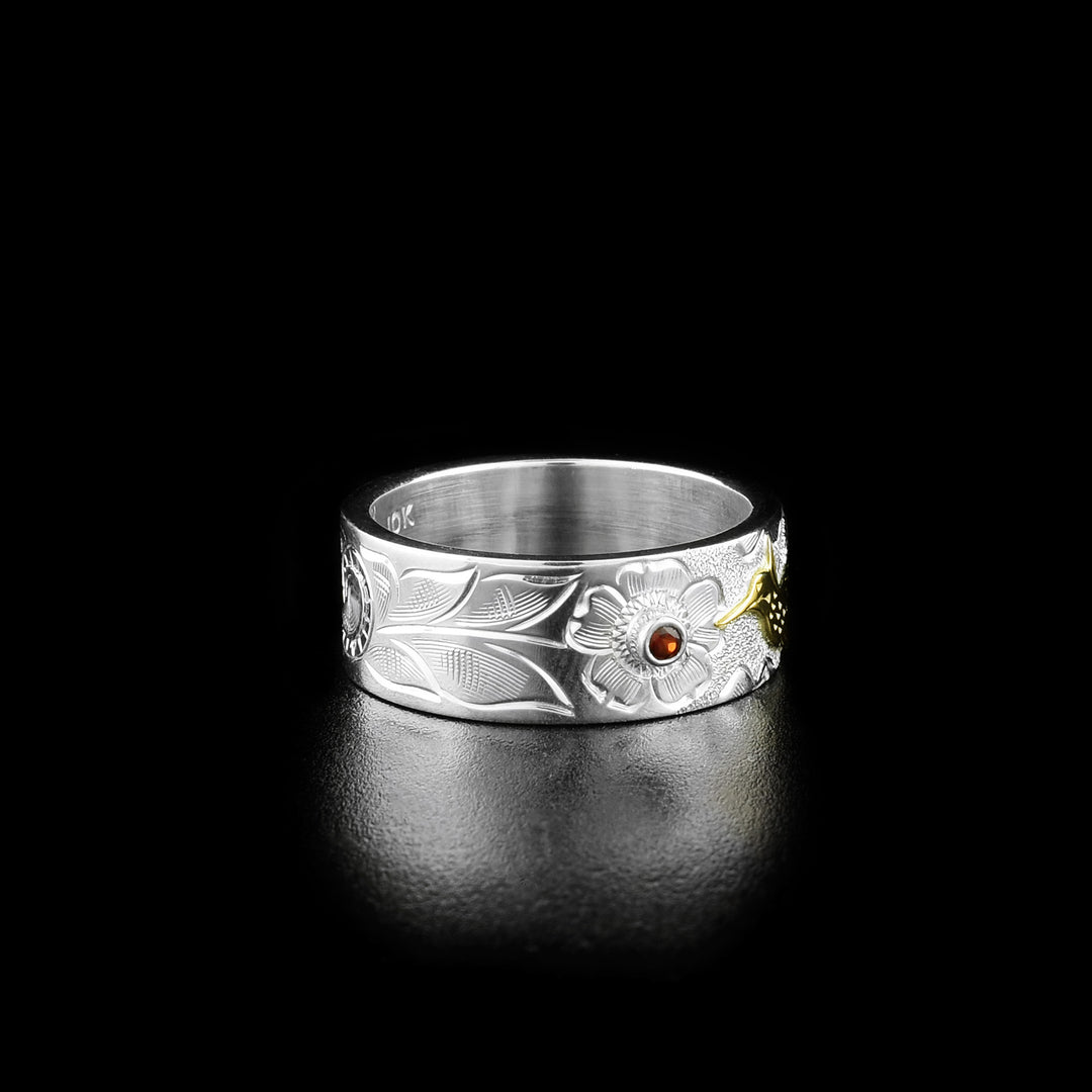 Left angle photo of the ring shows delicate designs representing the stem and leaves of the flower from which the hummingbird is drinking.