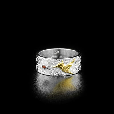 The front of this hummingbird ring has a small hummingbird made out of 10k yellow gold mid-flight and drinking from a flower. The flower has a small garnet set in the center.