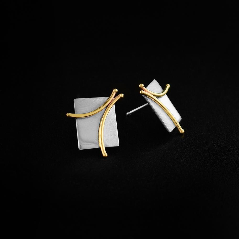 These silver square earrings are made from 14K gold and sterling silver. These stud earrings have a silver square surface with 14K gold branch designs made from wire.