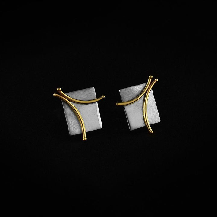 These silver square earrings are made from 14K gold and sterling silver. These stud earrings have a silver square surface with 14K gold branch designs made from wire.