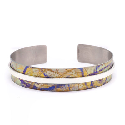 Gold Titanium Bracelet handmade by Jean-Yves Nantel. The titanium is anodized to achieve a vibrant gold colour before being fashioned into a bracelet. Nantel then uses a sterling silver strip in the center to accent the titanium.