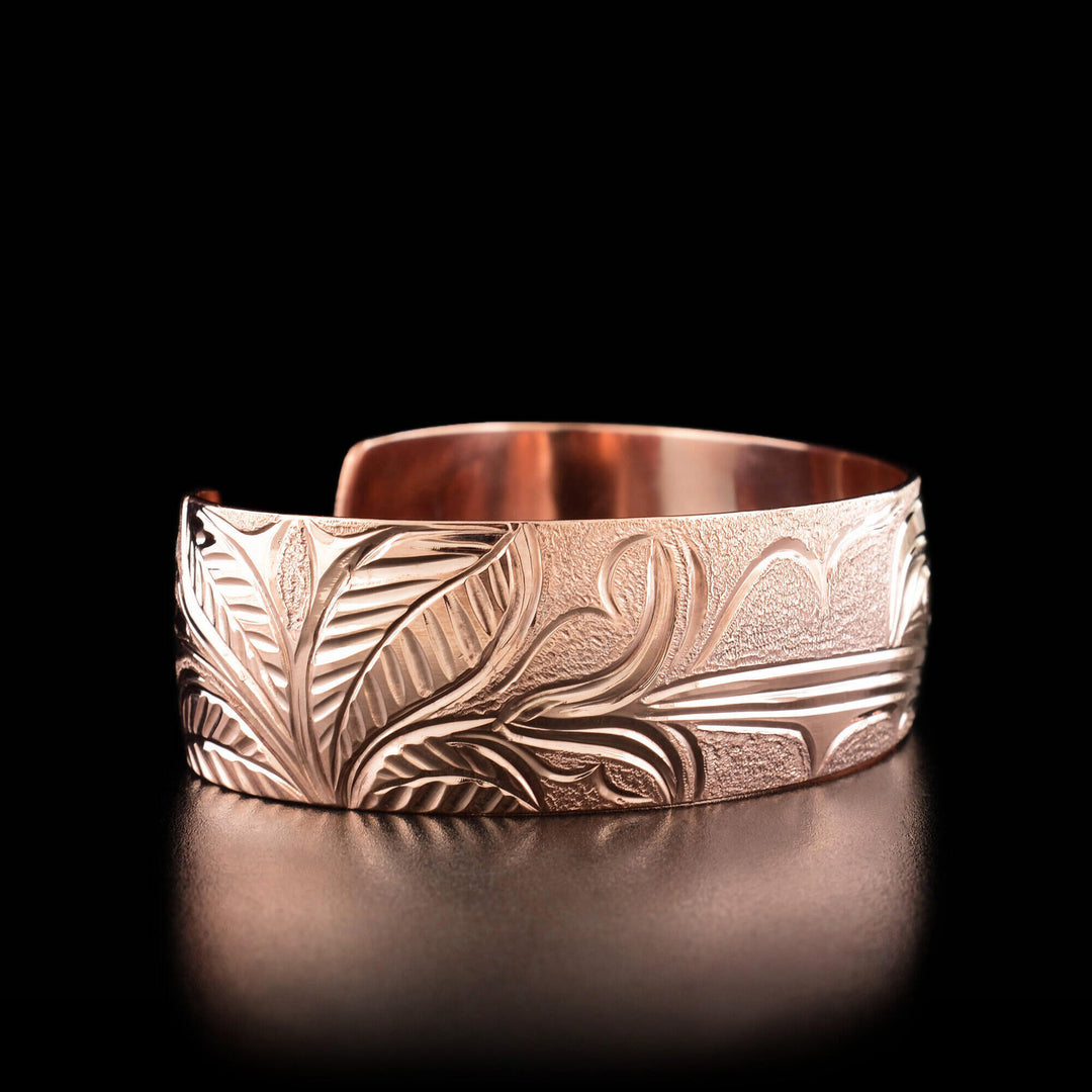 Left angle photo of the bracelet shows a carved flower and leaves.
