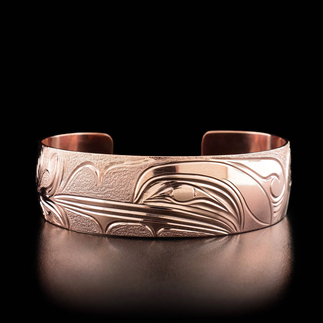 The center of this hummingbird bracelet has the profile of a hummingbird's head facing the left, drinking from a flower.