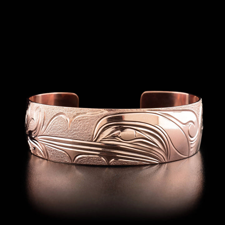 The center of this hummingbird bracelet has the profile of a hummingbird's head facing the left, drinking from a flower.