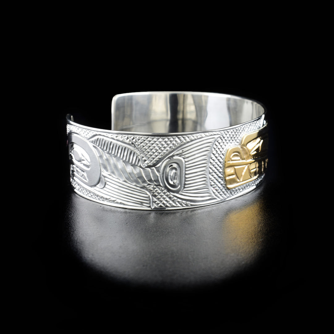 Left angle photo of the bracelet shows a carved salmon with a large tail swimming away from the bear.
