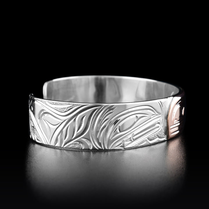 Left angle photo of the bracelet shows a second orca with a large fin leaping out of the water.