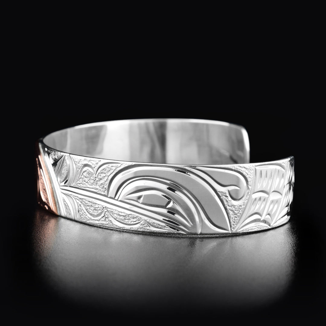 Right angle photo of the bracelet shows the profile of a hummingbird's head facing the left towards the moon. Behind is its wing.