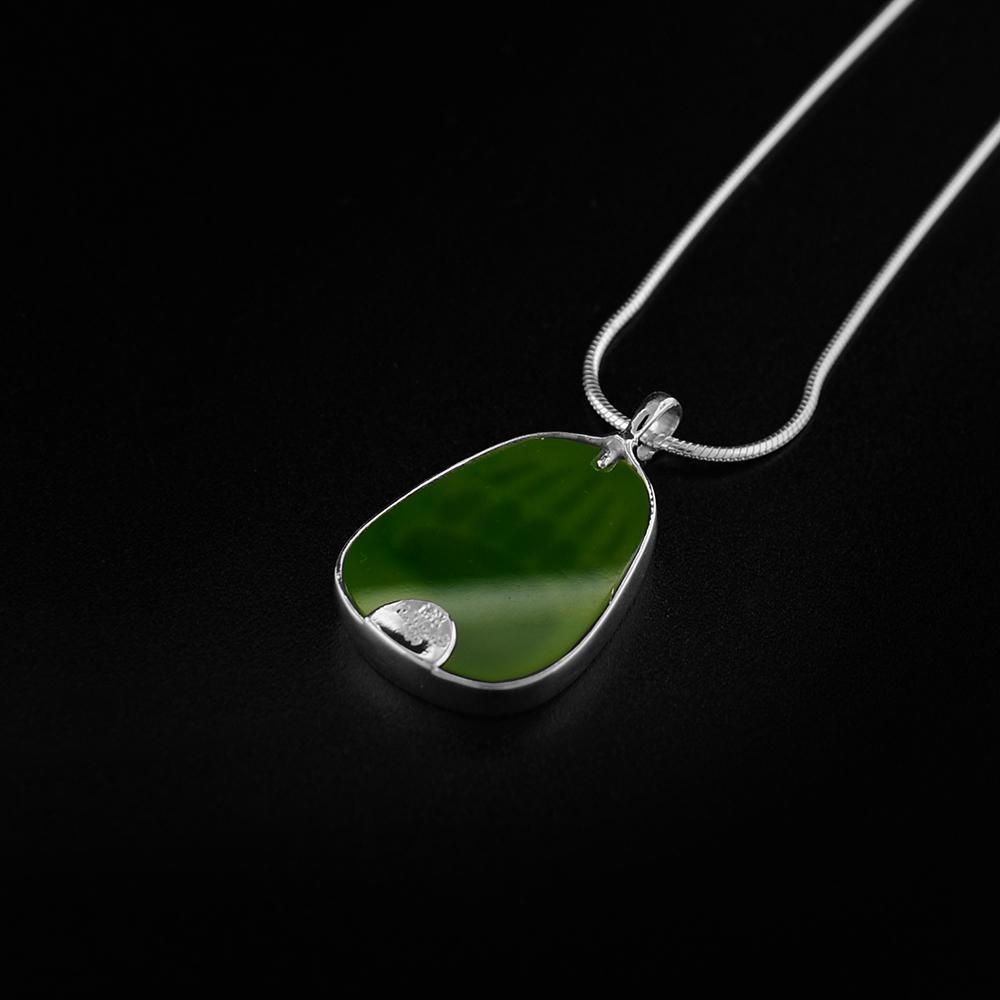 This gorgeous bear paw pendant is made from 14K gold, sterling silver and A+ grade BC jade. There is a bear paw cut out of a gold plate then set of the jade to give it a brilliant color. The pendant is oval shaped and is held in sterling silver.