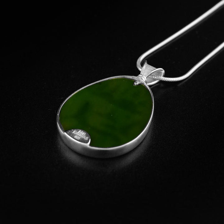 BC Jade Orca Passage PendantThis BC jade pendant is made from 14K gold, sterling silver and A + grade BC jade. He has engraved a scene on Orcas in the ocean on a gold plate that is then set onto of the jade to give unique color to the scene. The pendant is oval shaped and the sides of it are made from silver.
