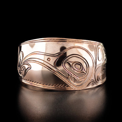 Copper Hummingbird Bracelet by Paddy Seaweed. The design depicts the profile of a hummingbird's head looking to the left with its beak in a flower. To the right of the head is the hummingbird's body and wings delicately carved.