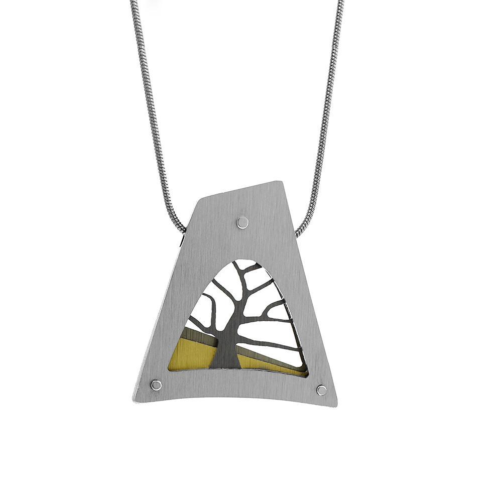 This tree pendant necklace is made from brushed aluminum, anodized aluminum and stainless steel. The pendant is wide, tapered and has a cutout depiction of a tree in nature.