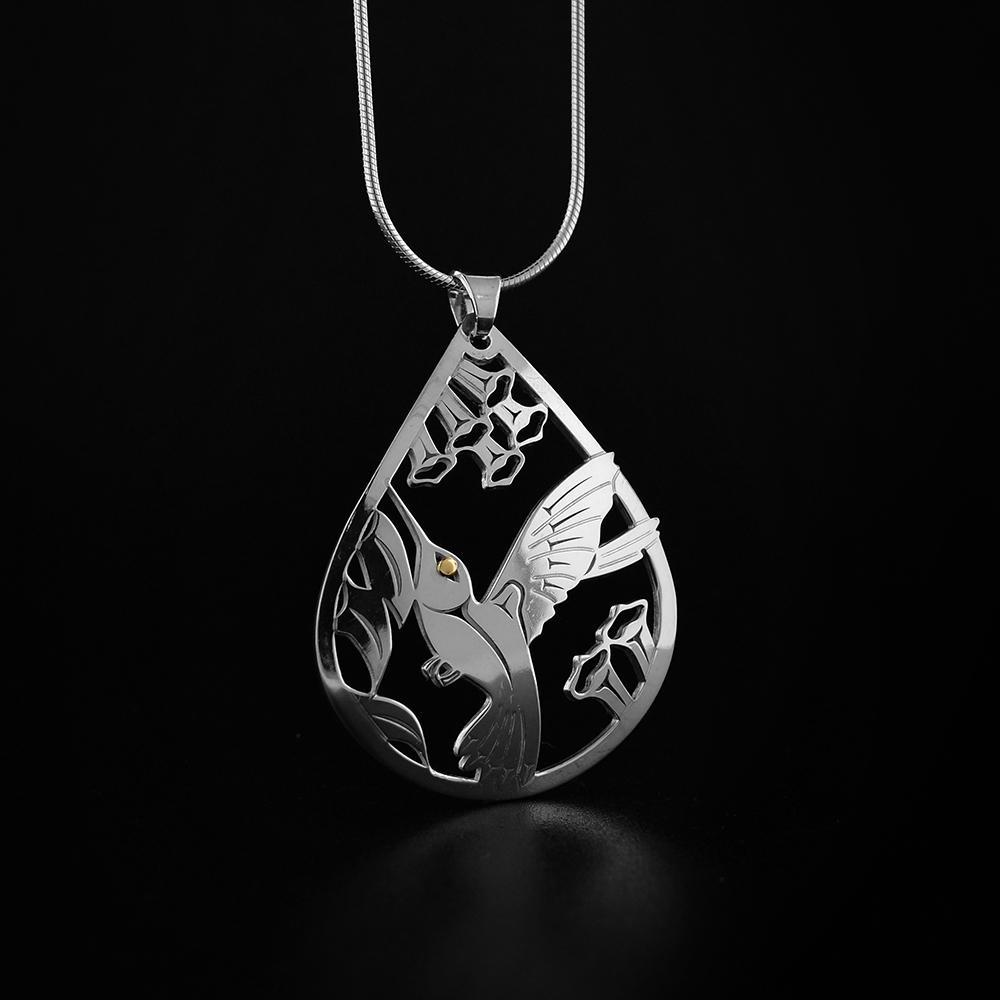This elegant Hummingbird pendant is made from sterling silver and 18K gold and is teardrop shaped. There is a cutout design depiction the Hummingbird that has been cast into the pendant. The eye of the Hummingbird is made from 18K gold.