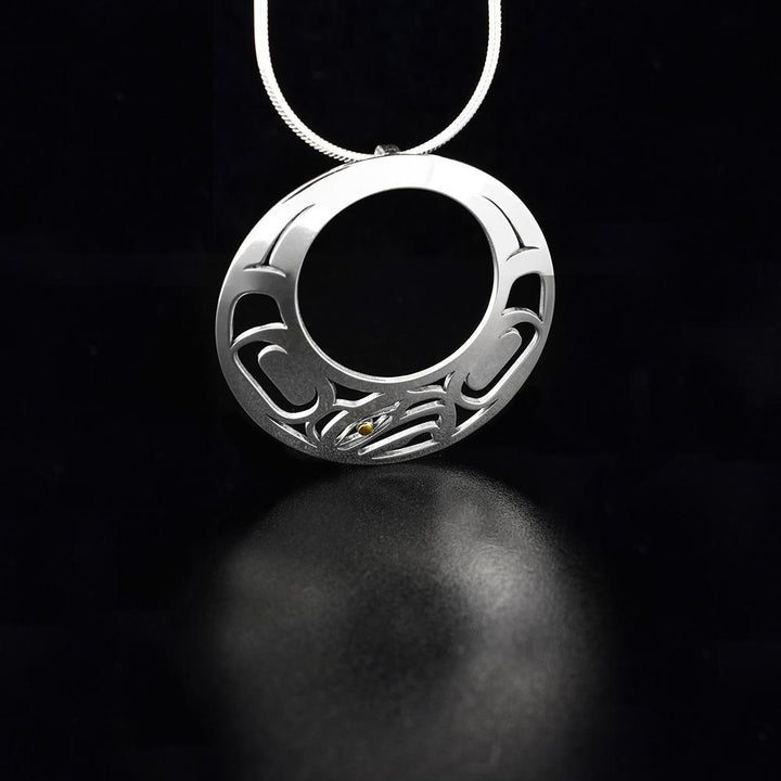 This Eagle pendant is made from sterling silver and 18K gold with a large, circle shape with a circle cutout in the middle. There are also cutout designs in the pendant that depict the Eagle; the eye of the Eagle is made form 18K gold.