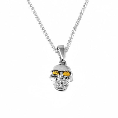 22K Gold Nugget Skull Pendant by Tom Gregorczyk. The pendant is shaped like a skull with 22k gold nuggets in both of the eyes. The rest of the pendant is made using sterling silver.
